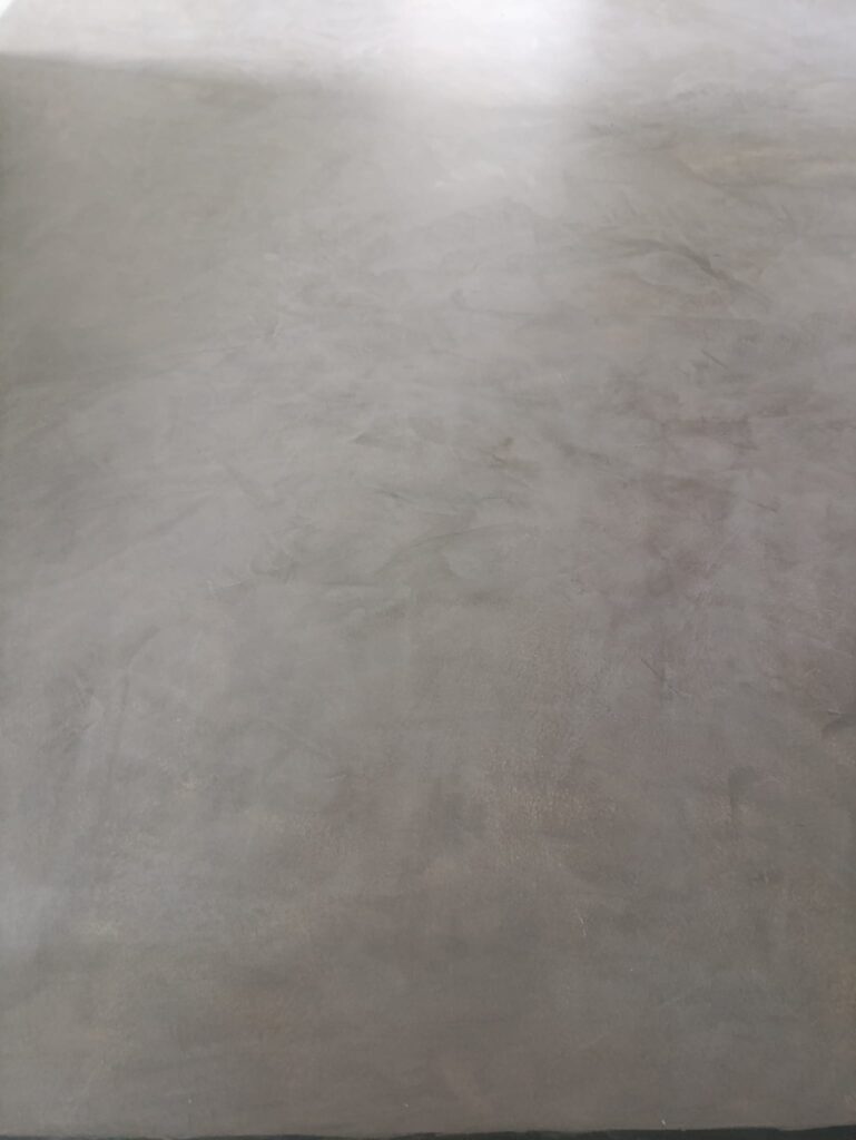 Seamless microcement bathroom with matching walls and floor finish by Silk Plaster